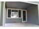 Covered patio with a large window and entrance door to the house at 213 Mesa St, Brighton, CO 80601