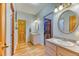 Bright bathroom featuring double vanity, wood floors, and neutral paint at 5400 S Alkire St, Littleton, CO 80127