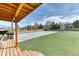 Covered wooden deck with an outdoor grill overlooking the large backyard and basketball court at 5400 S Alkire St, Littleton, CO 80127