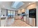 Bright kitchen with a large skylight, stainless steel appliances, tile flooring, and ample counter space at 5400 S Alkire St, Littleton, CO 80127