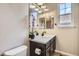 Bathroom vanity with dark cabinets, quartz countertops, a mirror and a window at 9527 Iron Mountain Way, Arvada, CO 80007