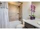 Tiled shower with a shower curtain in a well-lit bathroom with a toilet and sink at 9527 Iron Mountain Way, Arvada, CO 80007