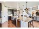 Bright, open kitchen with a large island, dark wood cabinets, and modern stainless steel appliances at 9527 Iron Mountain Way, Arvada, CO 80007