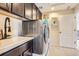 Clean laundry room equipped with a washer, dryer, sink, cabinets, and well-organized storage at 9527 Iron Mountain Way, Arvada, CO 80007