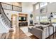 Open-concept living room with a fireplace, large windows, and beautiful hardwood floors at 9527 Iron Mountain Way, Arvada, CO 80007