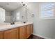 Bright bathroom features double sink vanity, a large mirror, natural light and neutral tones at 6139 Raleigh Cir, Castle Rock, CO 80104
