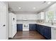 Bright kitchen featuring white and navy cabinets, modern appliances, and a window with plantation shutters at 6139 Raleigh Cir, Castle Rock, CO 80104
