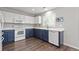 Modern kitchen with white and navy cabinets, stainless appliances, and hardwood floors at 6139 Raleigh Cir, Castle Rock, CO 80104