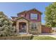 Charming two-story home with stone accents, covered entry, and a well-manicured front yard at 10811 Chambers Way, Commerce City, CO 80022