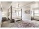 Serene main bedroom with tray ceilings, a plush bed, cozy bench, and a luxurious, comfortable aesthetic at 10811 Chambers Way, Commerce City, CO 80022