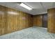 Retro basement rec room with wood paneling, drop ceiling, and vintage carpet at 4391 W Tufts Ave, Denver, CO 80236