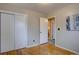 Spacious bedroom with hardwood floors, closet, and view into an en-suite bathroom creates an inviting private retreat at 4391 W Tufts Ave, Denver, CO 80236