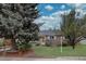Charming brick home featuring a well-maintained front yard with mature trees under a bright sky at 4391 W Tufts Ave, Denver, CO 80236