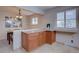 Inviting breakfast bar with wooden cabinets and granite countertops next to dining area filled with natural light at 4391 W Tufts Ave, Denver, CO 80236