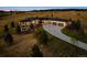 Stunning aerial view of modern home with landscaped yard and circular driveway at dusk at 2937 Hidden Den Ct, Franktown, CO 80116