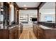 Custom wet bar with granite countertops, dark wood cabinetry and shelving in the finished basement at 2937 Hidden Den Ct, Franktown, CO 80116