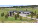 View of home featuring gray roof, outdoor patio, stone facade, manicured lawns, and garage at 2937 Hidden Den Ct, Franktown, CO 80116
