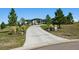 Home exterior featuring a long driveway, landscaping, and stone accents at 2937 Hidden Den Ct, Franktown, CO 80116