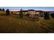 Exterior view of a well-kept home featuring stone accents, a covered patio, and surrounding greenery at 2937 Hidden Den Ct, Franktown, CO 80116