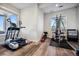 Home gym featuring an elliptical machine, weight rack and ample natural light from two windows at 2937 Hidden Den Ct, Franktown, CO 80116