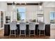 Stylish kitchen island with seating, granite countertops, and white cabinets, complemented by modern pendant lighting at 2937 Hidden Den Ct, Franktown, CO 80116