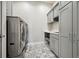 Laundry room with gray cabinets, countertop, and patterned tile floor at 2937 Hidden Den Ct, Franktown, CO 80116