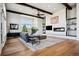 Living room featuring hardwood floors, fireplace, beamed ceiling, and large window at 2937 Hidden Den Ct, Franktown, CO 80116