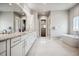 Spacious bathroom with double vanity, soaking tub, and white cabinets at 2937 Hidden Den Ct, Franktown, CO 80116