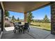 Covered outdoor patio featuring natural stone columns with patio furniture, and peaceful views at 2937 Hidden Den Ct, Franktown, CO 80116