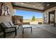 Covered patio with stone fireplace, cozy seating, and views of a field at 2937 Hidden Den Ct, Franktown, CO 80116