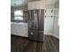 Updated kitchen featuring stainless steel appliances, white cabinets, grey backsplash, and wood floating shelves at 2242 S Uravan St, Aurora, CO 80013