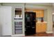 Modern kitchen with black refrigerator, a wine cooler, wooden cabinets, and convenient built-in storage solutions at 4673 Perth St, Denver, CO 80249