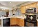 This kitchen has wooden cabinets, stainless steel microwave, and a large sink for easy cleanup and meal prep at 4673 Perth St, Denver, CO 80249