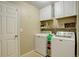 Functional laundry room featuring a washer, dryer, and storage cabinets at 4673 Perth St, Denver, CO 80249