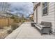 Back patio area featuring outdoor seating, privacy fence, and stone pavers on a cloudy day at 10776 Hillsboro Cir, Parker, CO 80134