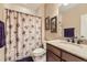 Bathroom with floral shower curtain, granite countertop, decorative art, and neutral color paint creating a calming space at 10776 Hillsboro Cir, Parker, CO 80134