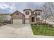 Charming two-story home with stone accents, red shutters, three-car garage, and well-manicured lawn at 10776 Hillsboro Cir, Parker, CO 80134