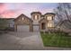 Charming two-story home with stone accents, red shutters, three-car garage, and well-manicured lawn at 10776 Hillsboro Cir, Parker, CO 80134