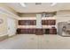 Well-organized garage with epoxy flooring, abundant cabinet space, stainless steel refrigerator, and a secondary access door at 10776 Hillsboro Cir, Parker, CO 80134