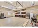 Spacious garage features epoxy floors, ample storage cabinets, stainless steel refrigerator, and overhead lighting at 10776 Hillsboro Cir, Parker, CO 80134