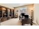 Inviting home office features a large desk, built-in bookshelves, and a comfortable seating area near a window at 10776 Hillsboro Cir, Parker, CO 80134