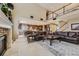 Open-concept living room with a fireplace, soaring ceilings, and seamless access to the adjacent dining area at 10776 Hillsboro Cir, Parker, CO 80134