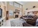 Spacious living room with high ceilings, a fireplace, and large windows offering plenty of natural light at 10776 Hillsboro Cir, Parker, CO 80134
