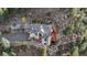 Aerial view of gray roofed home, nestled between a rock wall and natural forest at 900 Sawmill Creek Rd, Evergreen, CO 80439