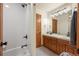 Well-lit bathroom featuring double sinks, a walk-in shower, and wood cabinets at 900 Sawmill Creek Rd, Evergreen, CO 80439