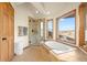 Bright bathroom showcases a soaking tub with views, a glass shower, and tile flooring at 900 Sawmill Creek Rd, Evergreen, CO 80439