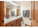 Bathroom featuring double sinks with tile counters, warm wood cabinets, and modern fixtures at 900 Sawmill Creek Rd, Evergreen, CO 80439
