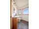 Cozy bathroom with wood vanity, neutral tile floor, and natural light from two windows with mountain views at 900 Sawmill Creek Rd, Evergreen, CO 80439