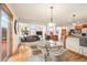 Bright dining area with a glass table, chairs, hardwood floors, and an open layout connected to the living room at 900 Sawmill Creek Rd, Evergreen, CO 80439