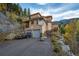Inviting multi-story home featuring a two-car garage and beautiful stone landscaping at 900 Sawmill Creek Rd, Evergreen, CO 80439